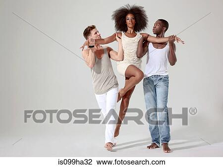 Stock Image - Two men holding a young woman off the ground. Fotosearch