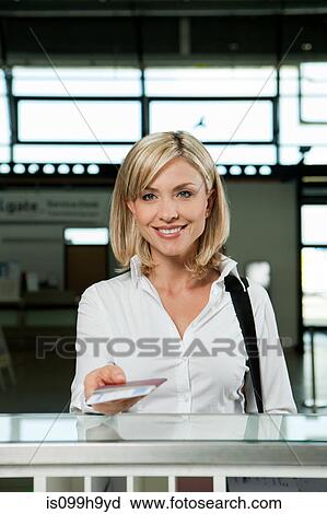 Woman with plane tickets at check in desk of airport View Large Photo Image Stock Image - Woman with plane tickets at check in desk of airport. Fotosearch