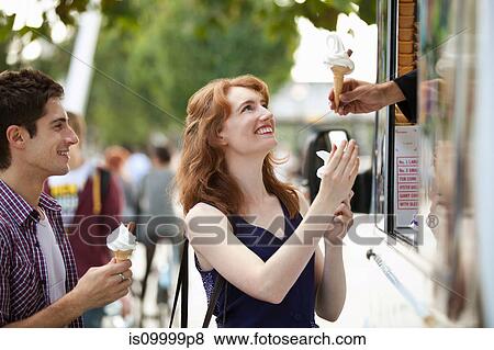 Stock Photo - Young couple buying icecreams from a van. Fotosearch