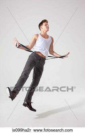 Young man in mid air pulling trouser braces View Large Photo Image Stock Photography - Young man in mid air pulling trouser braces. Fotosearch