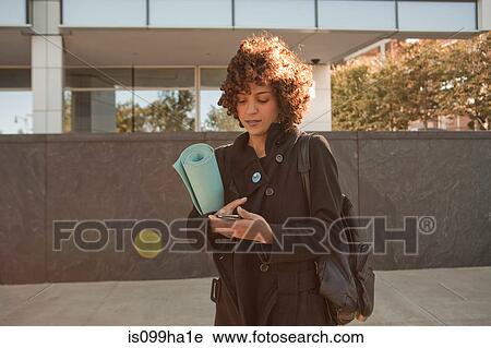 Young woman carrying a yoga mat View Large Photo Image Stock Image - Young woman carrying a yoga mat. Fotosearch