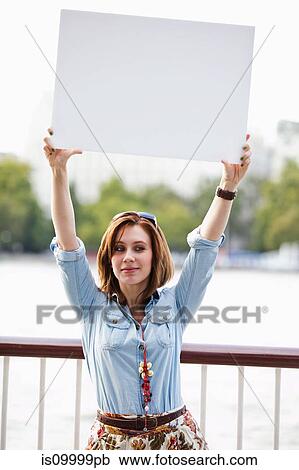 Young woman holding up a white board View Large Photo Image Stock Image - Young woman holding up a white board. Fotosearch