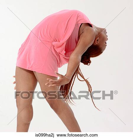Stock Image - Young woman in pink bending over backwards. Fotosearch