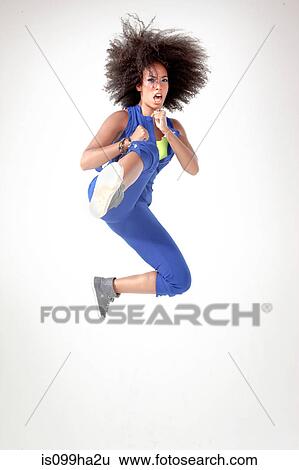 Young woman kicking in mid air View Large Photo Image Stock Photograph - Young woman kicking in mid air. Fotosearch