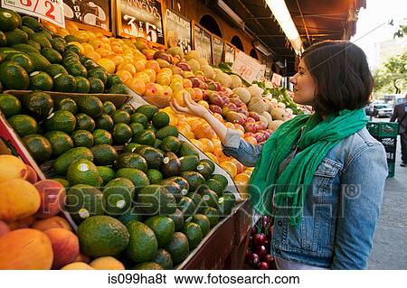 Young woman shopping at market stall View Large Photo Image Stock Photograph - Young woman shopping at market stall. Fotosearch