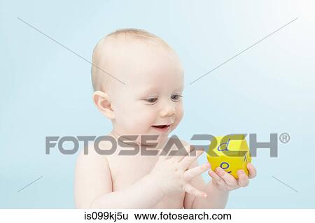 Stock Photograph - Baby looking at alphabet cube. Fotosearch