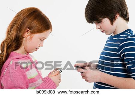 Boy and girl looking at smartphones View Large Photo Image Stock Photo - Boy and girl looking at smartphones. Fotosearch