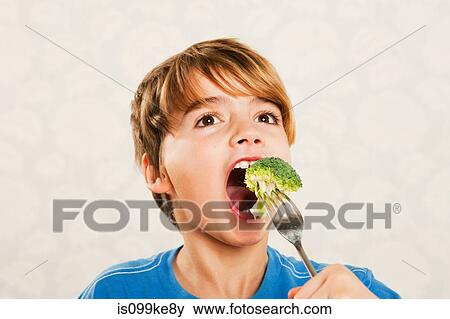 Boy eating broccoli View Large Photo Image Stock Photo - Boy eating broccoli. Fotosearch
