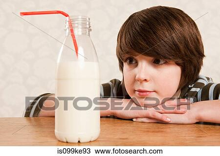 Boy looking at bottle of milk View Large Photo Image Stock Image - Boy looking at bottle of milk. Fotosearch