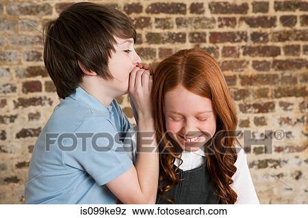Boy whispering to girl View Large Photo Image Stock Photo - Boy whispering to girl. Fotosearch