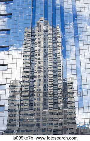 Stock Image - Building reflected in glass of skyscraper. Fotosearch