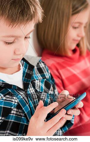 Children using smartphones View Large Photo Image Stock Photo - Children using smartphones. Fotosearch
