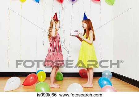 Girl giving birthday gift to friend View Large Photo Image Stock Photograph - Girl giving birthday gift to friend. Fotosearch
