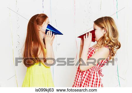 Stock Image - Girls playing with party hats. Fotosearch