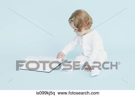 Little girl looking at a book View Large Photo Image Stock Photography - Little girl looking at a book. Fotosearch