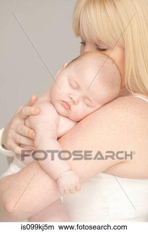 Mother holding sleeping baby girl View Large Photo Image Picture - Mother holding sleeping baby girl. Fotosearch