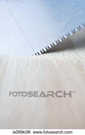 Saw cutting a piece of wood View Large Photo Image Stock Photograph - Saw cutting a piece of wood. Fotosearch