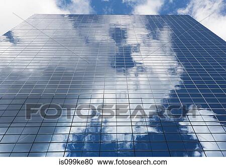 Stock Image - Sky reflected in glass skyscraper. Fotosearch