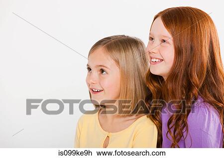 Stock Image - Two girls looking up. Fotosearch