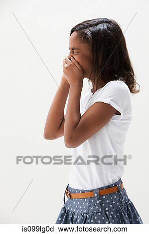 Stock Image - African American girl laughing, studio shot. Fotosearch