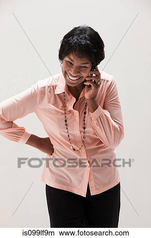 Picture - African American mature woman using cellphone, studio shot. Fotosearch