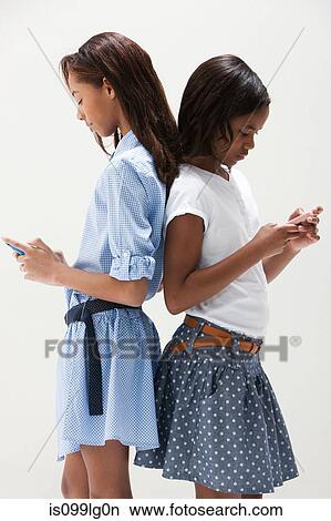 African American sisters using cellphones, studio shot View Large Photo Image Picture - African American sisters using cellphones, studio shot. Fotosearch