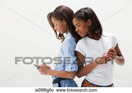 African American sisters using cellphones, studio shot View Large Photo Image Picture - African American sisters using cellphones, studio shot. Fotosearch