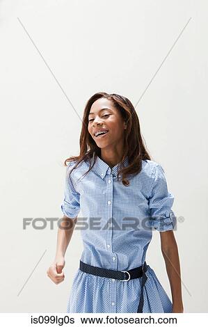 Stock Photograph - African American teenage girl dancing, studio shot. Fotosearch