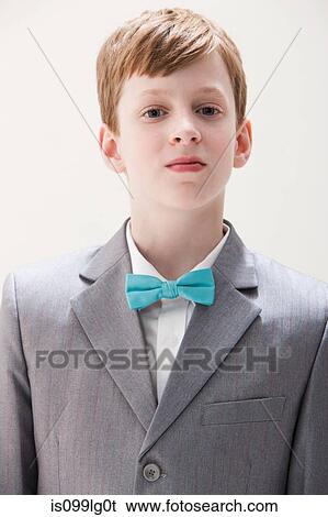 Stock Photograph - Boy wearing grey suit and bow tie, studio shot. Fotosearch