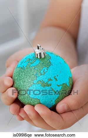 Stock Image - Girl holding globe decoration. Fotosearch