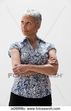 Picture - Girl in red with hands behind head, studio shot. Fotosearch