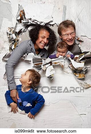 Stock Photograph - Happy family busting through a wall. Fotosearch