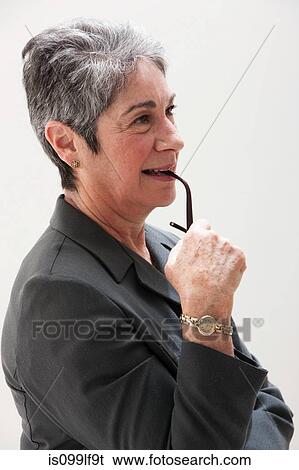 Stock Photograph - Mature businesswoman thinking, studio shot. Fotosearch
