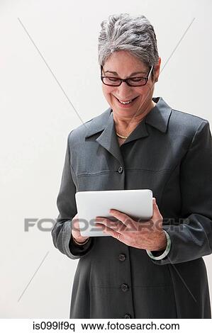 Mature businesswoman using digital tablet, studio shot View Large Photo Image Stock Photography - Mature businesswoman using digital tablet, studio shot. Fotosearch