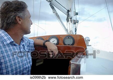 Stock Image - Mature man at ships bridge. Fotosearch