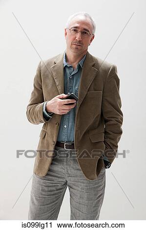 Mature man holding cellphone, studio shot View Large Photo Image Stock Image - Mature man holding cellphone, studio shot. Fotosearch