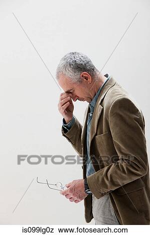 Mature man rubbing eyes, studio shot View Large Photo Image Stock Photo - Mature man rubbing eyes, studio shot. Fotosearch