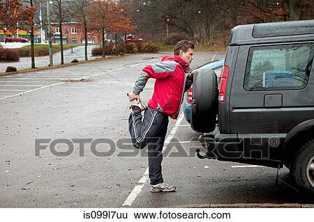 Mature man stretching against car in car park View Large Photo Image Stock Photograph - Mature man stretching against car in car park. Fotosearch