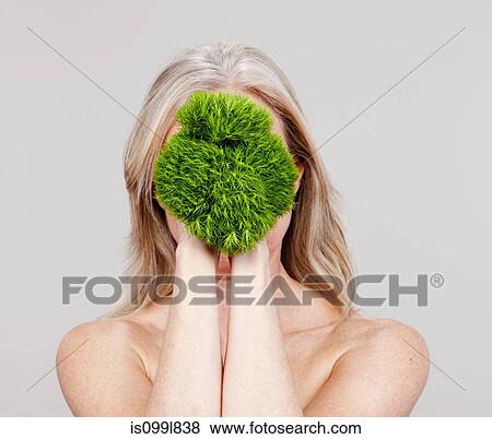 Mature woman holding plant in front of face View Large Photo Image Stock Photo - Mature woman holding plant in front of face. Fotosearch