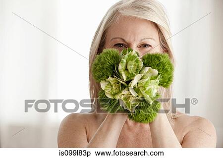 Mature woman holding plant, portrait View Large Photo Image Stock Photography - Mature woman holding plant, portrait. Fotosearch