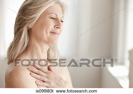 Stock Photograph - Mature woman touching neck. Fotosearch