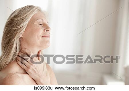 Mature woman touching neck View Large Photo Image Stock Photograph - Mature woman touching neck. Fotosearch