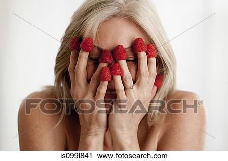 Mature woman wearing raspberries on fingers and covering face View Large Photo Image Stock Image - Mature woman wearing raspberries on fingers and covering face. Fotosearch