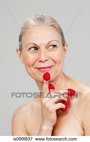 Mature woman wearing raspberries on fingertips, smiling View Large Photo Image Stock Photo - Mature woman wearing raspberries on fingertips, smiling. Fotosearch