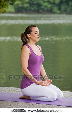 Mid adult woman performing yoga by river View Large Photo Image Picture - Mid adult woman performing yoga by river. Fotosearch
