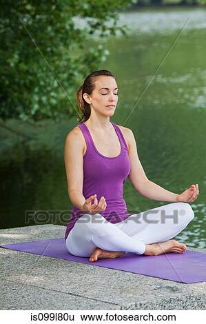 Mid adult woman performing yoga by river View Large Photo Image Stock Photograph - Mid adult woman performing yoga by river. Fotosearch