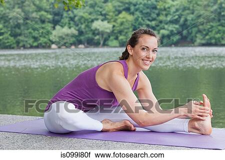 Mid adult woman performing yoga by river, portrait View Large Photo Image Stock Image - Mid adult woman performing yoga by river, portrait. Fotosearch