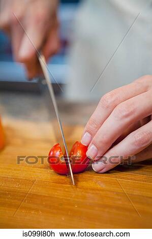Mid adult woman slicing cherry tomatoes View Large Photo Image Stock Image - Mid adult woman slicing cherry tomatoes. Fotosearch
