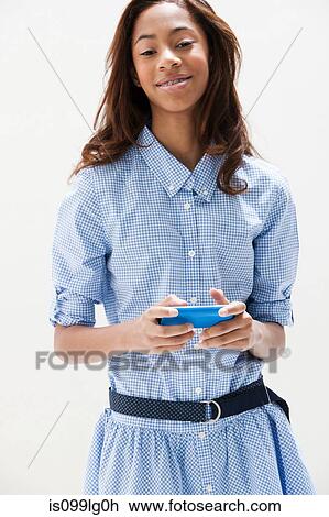 Stock Image - Portrait of African American teenage girl, studio shot. Fotosearch