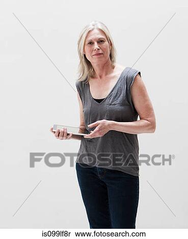 Portrait of mature woman using digital tablet, studio shot View Large Photo Image Stock Photography - Portrait of mature woman using digital tablet, studio shot. Fotosearch